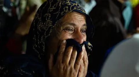 Getty Images Seorang wanita menangis saat menunggu di pusat kesehatan primer di Meppadi, distrik Wayanad, Kerala, India pada 30 Juli 2024.