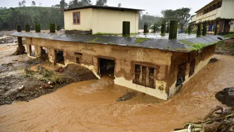 Air banjir EPA mengalir melalui sebuah rumah setelah tanah longsor di Myilambadi, distrik Wayanad, Kerala, India selatan pada 30 Juli