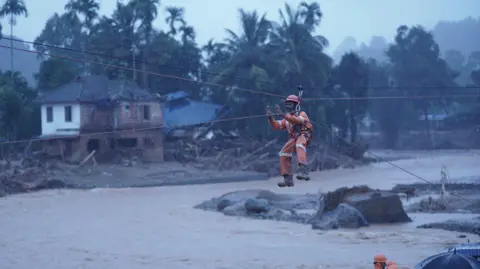 Anggota tim penyelamat Reuters sedang melakukan operasi penyelamatan di lokasi longsor setelah beberapa kali terjadi tanah longsor di perbukitan Wayanad.