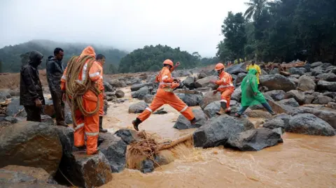 Anggota tim penyelamat Reuters bergegas ke lokasi longsor setelah beberapa kali terjadi longsor di perbukitan Wayanad.