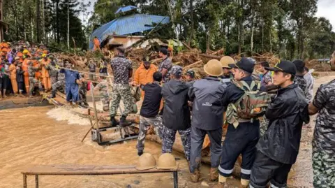 Tim penyelamat Arun Chandra Bose menggunakan tali untuk menyeberangi jembatan yang rusak dan menyelamatkan korban di Wayanad