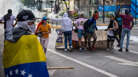 Polisi anti huru hara EPA menembakkan gas air mata dan peluru karet ke arah pengunjuk rasa di Caracas ketika ribuan orang berdemonstrasi menentang hasil pemilihan presiden hari Minggu.