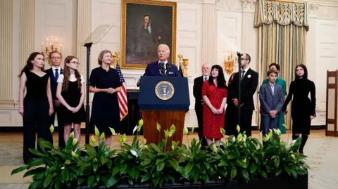 Getty Images Presiden Biden (tengah) bergabung dengan keluarga tahanan yang dibebaskan di Gedung Putih