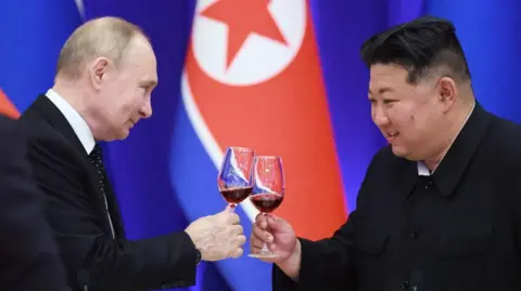 Getty Images Presiden AS Vladimir Putin dan pemimpin Korea Utara Kim Jong Un bersulang saat resepsi di Rumah Penerimaan Mongnangwon di Pyongyang pada 19 Juni 2024.