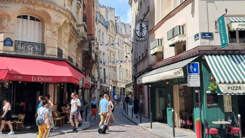 Orang-orang berjalan melalui jalan di Latin Quarter Paris