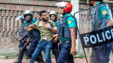 Polisi EPA Bangladesh menahan seorang pengunjuk rasa saat demonstrasi di depan Mahkamah Agung di Dhaka, Bangladesh pada 31 Juli.