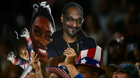 Getty Images Penggemar memegang gambar poster Snoop Dogg di tribun Olimpiade