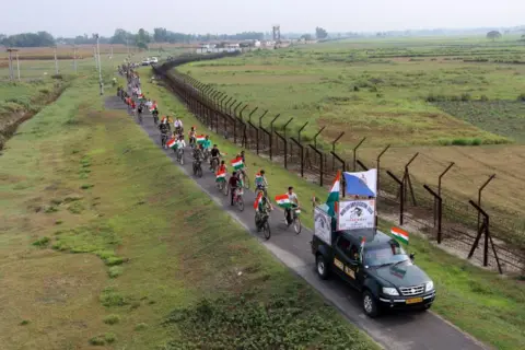 AFP Personel Pasukan Keamanan Perbatasan India (BSF) berpartisipasi dalam unjuk rasa kesadaran bersepeda bersama pemuda di perbatasan India-Bangladesh di desa Parial dekat Raiganj di distrik Dinajpur Utara, Benggala Barat pada 14 Mei 2024.