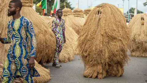     PORTO-NOVO, BENIN - Parade topeng Zangbeto pada Prosesi Akbar Topeng Tradisional pada 4 Agustus 2024 oleh Yannick Foley / AFP. 