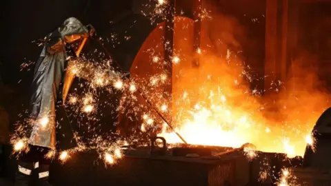 Getty Images Percikan api beterbangan saat seorang pekerja mengambil sampel besi cair yang mengalir dari tanur tinggi di Duisburg, Jerman.