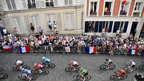 Getty Images Orang-orang naik ke ambang jendela untuk menonton pengendara sepeda selama Olimpiade Paris