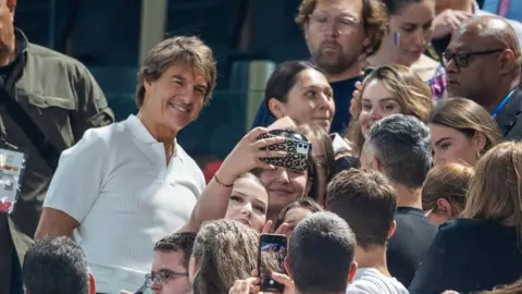 Getty Images Tom Cruise berpose untuk selfie dengan seorang penggemar di Paris