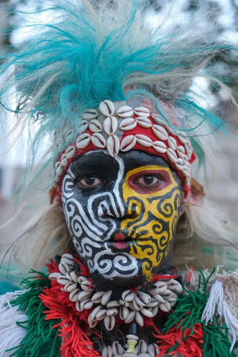     RICCI SHRYOCK / AFP Kostum tradisional Simb berpose saat pertunjukan budaya di Ngor, Dakar, pada 12 Agustus 2024. Simbs menampilkan tarian dan ritual sepanjang tahun di berbagai kesempatan di Senegal, seperti Hari Kemerdekaan dan liburan sekolah musim panas. , pertandingan gulat dan banyak lagi. 