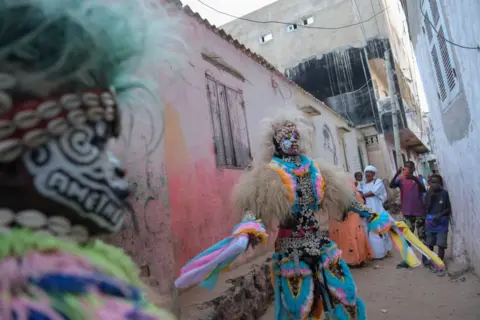 RICCI SHRYOCK / AFP Seekor Simb menari dengan pakaian adat saat pertunjukan budaya di Ngor, Dakar, pada 12 Agustus 2024. Simbs menampilkan tarian dan ritual sepanjang tahun di berbagai kesempatan di Senegal, seperti Hari Kemerdekaan dan liburan sekolah musim panas. , pertandingan gulat dan banyak lagi. (Foto oleh RICCI SHRYOCK / AFP) (Foto 