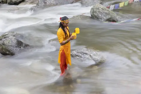 Narendra Shrestha / EPA-EFE Seorang peziarah Hindu Nepal mandi suci dan mengambil air dari Sungai Bagmati untuk memuja Dewa Siwa.