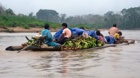 Sebuah perahu di sungai Maniqui penuh dengan manusia dan pisang