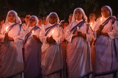 Getty Images Para biarawati Kristen India memegang lilin saat menyalakan lilin di luar gereja pada 3 Mei 2023, untuk memperingati satu tahun bentrokan kekerasan antara kelompok etnis Meites dan Kuki-Jo di negara bagian Manipur di timur laut pada 3 Mei 2023 . , pada 3 Mei 2024 di New Delhi, India. (