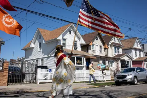 Getty Images Komunitas asal India merayakan Holi dengan Parade Phagwa tahunan pada 26 Maret 2023 di lingkungan Richmond Hill di Queens, New York.