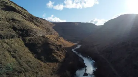 Sebuah sungai mengalir melalui sebuah lembah