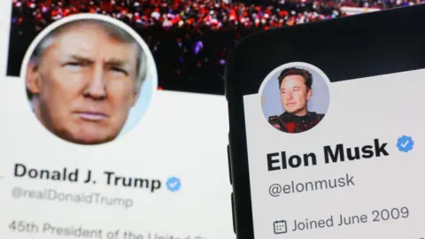 Foto Noor via Getty Images Akun Twitter Donald Trump ditampilkan di layar laptop dan akun Twitter Elon Musk ditampilkan di fitur layar ponsel pada foto ilustrasi ini