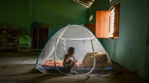 Getty Images Seorang anak etnis Kuki duduk di tenda di kamp bantuan untuk pengungsi internal di desa Litan, Manipur, India, pada 27 April 2024. 