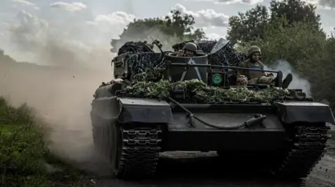 Reuters Dua tentara Ukraina duduk di atas tank di wilayah Sumy