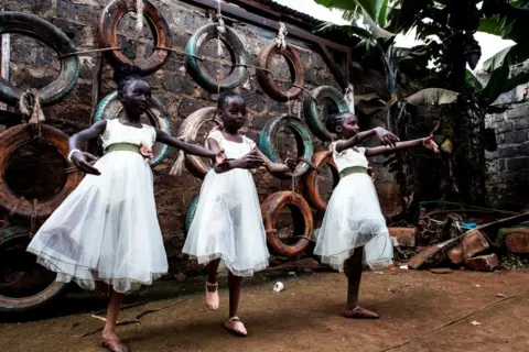 GORDWIN ODIAMBO / AFP Siswa balet dari Project Elimu yang berbasis di Kibera melakukan pemanasan sebelum pertunjukan publik di Kibera. Mereka mengenakan tulle putih.