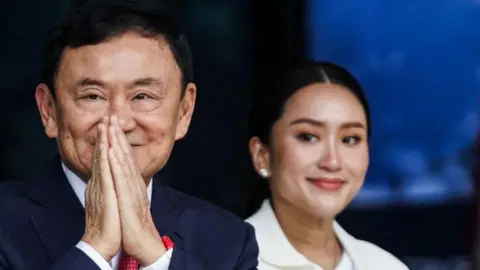 Getty Images Thaksin Shinawatra menyapa pendukungnya bersama putrinya yang masih kecil Patongtarn Shinawatra pada 22 Agustus 2023.