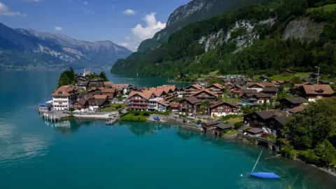 AFP Sebuah kota di tepi Danau Brienz di Pegunungan Alpen Swiss dengan pegunungan di belakangnya