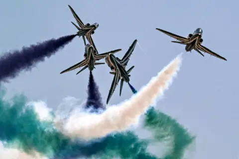 Khalid Dessouki/AFP BAE Hawk pesawat latih tim aerobatik Saudi Falcons Angkatan Udara Kerajaan Saudi mengeluarkan asap saat mereka terbang melewatinya