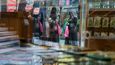 Getty Images KABUL, AFGHANISTAN-14 MEI: Wanita berjalan melewati pajangan ponsel dan aksesoris di sebuah toko pada 14 Mei 2024 di Kabul, Afghanistan. Tiga tahun setelah pengambilalihan Taliban, perempuan dan anak perempuan Afghanistan menggunakan Internet. Kesenjangan akibat pelarangan berdampak pada pendidikan, pekerjaan dan kehidupan sosial perempuan. (Foto oleh Carolyn Van Houten/The Washington Post melalui Getty Images)