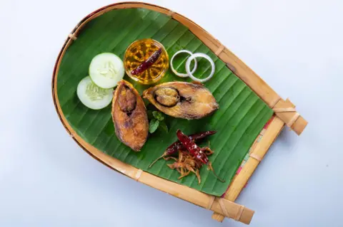 Ilish Bhaji untuk Panta Ilish, resep Malam Tahun Baru Bengali. Potongan Hilsha digoreng dengan cabai, tomat, dan bawang bombay. Hilsa Fry populer di Pohela Boishak. pada kasta.