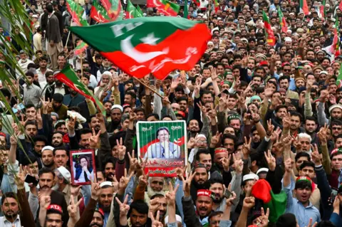 Getty Images Kerumunan besar mengibarkan bendera dan plakat untuk mendukung Imran Khan