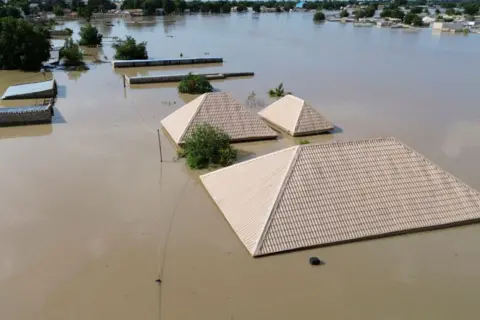 AUDU MARTE / AFP Atap tampak mengambang di atas air setelah banjir dahsyat.