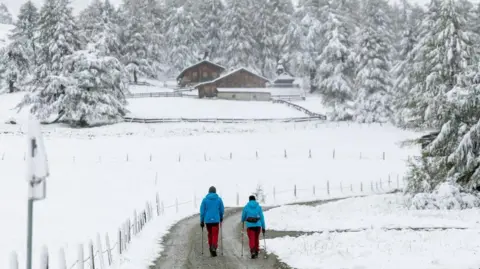 Johann Groder/APA/EXPA/AFP Pejalan kaki berjalan melalui lanskap tertutup salju di lembah Kalser Kodnitztal di Kals am Grossglockner, Tyrol, Austria pada 13 September 2024.