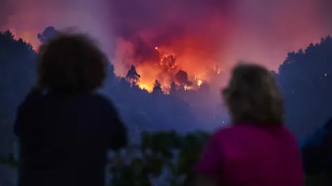 Orang-orang EPA menyaksikan kebakaran hutan menyebar di Silvares, Portugal pada hari Jumat