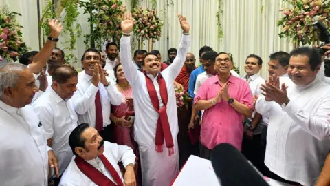 Getty Images Kandidat Presiden Namal Rajapaksa (tengah), keturunan keluarga Rajapaksa Sri Lanka, memberi isyarat saat menerima tiket dari partai Sri Lanka Podujana Peramuna (SLPP) di Kolombo pada 7 Agustus 2024. 