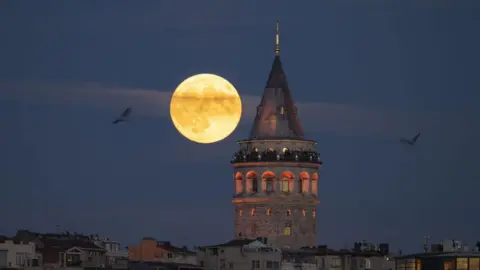 Getty Images Bulan purnama terbit di belakang Menara Galata di Istanbul, Turki