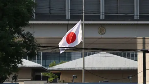 Getty Images Bendera Jepang berkibar setengah tiang di luar Kedutaan Besar Jepang di Beijing pada 19 September 2024.