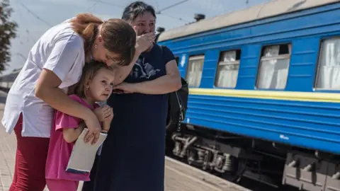 Getty Images Warga Ukraina menangis di dekat kereta api di Pokrovsk