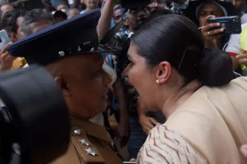 Getty Images Seorang wanita di tengah kerumunan berteriak kepada petugas 