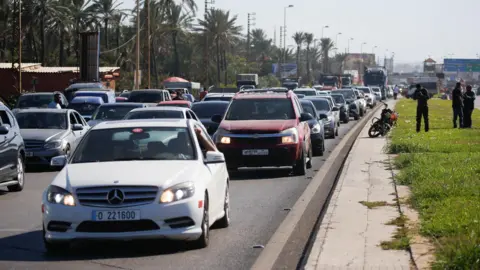 Reuters Mobil terjebak dalam kemacetan lalu lintas di jalan dari kota Sidon di selatan Lebanon di tengah serangan udara Israel yang intens (23 September 2024).