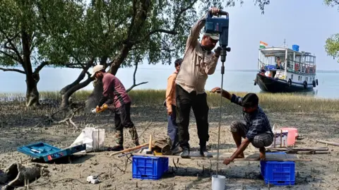 Para peneliti Sahadev Sharma sedang mengebor lubang di tanah