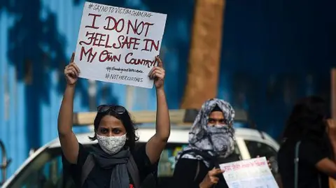 Getty Images Aktivis memegang plakat saat protes terhadap pemerkosaan beramai-ramai dan pembunuhan seorang gadis berusia 19 tahun di desa Boolgarhi di negara bagian Uttar Pradesh, Mumbai, pada 6 Oktober 2020.