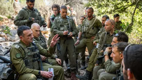 Foto selebaran militer IDF Israel Kepala Staf Letjen Herzi Halevi (kiri) berbicara dengan tentara Brigade ke-7 yang berpartisipasi dalam latihan di perbatasan utara Israel pada 24 September 2024