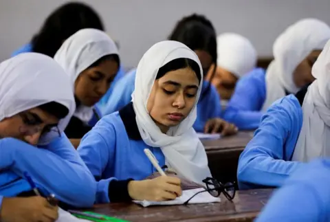     Mohamed Abd El Ghani / Reuters Siswa menghadiri kelas pada hari pertama tahun ajaran di Sekolah Orman di Kairo, Mesir pada 22 September 2024. 