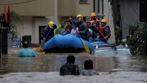 Petugas keamanan Reuters menggunakan rakit tiup untuk menyelamatkan warga dari daerah banjir di tepi Sungai Bagmati yang meluap setelah hujan lebat di Kathmandu, Nepal.