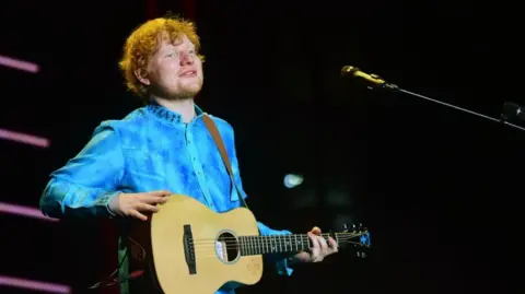 AFP Penyanyi dan penulis lagu asal Inggris Ed Sheeran tampil di sebuah konser di Mumbai pada 19 November 2017. 