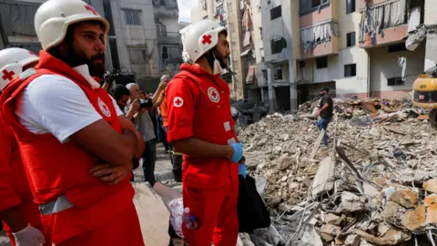 Reuters Personel medis bekerja di lokasi serangan Israel pada hari Jumat, sementara operasi pencarian dan penyelamatan berlanjut pada hari Sabtu