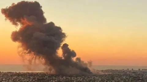 Getty Images Asap mengepul di pinggiran selatan Beirut selama serangan Israel.